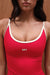 Red tank top with white straps and 'SET' logo worn by a person against a wooden background