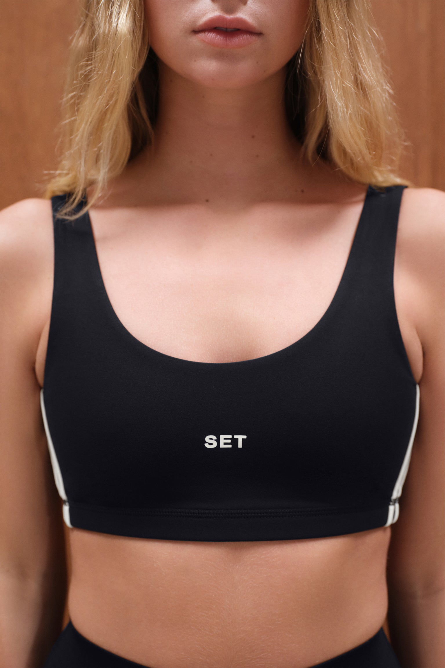 Black sports bra with 'SET' logo worn by a person against a neutral background