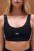 Black sports bra with 'SET' logo worn by a person against a neutral background