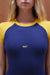 Blue and yellow top with 'SET' logo on a model against a brown background