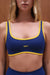Blue sports bra with yellow accents and 'SET' branding on a brown background