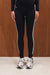 Person wearing black leggings with white stripes and silver sneakers on a wooden floor. <model-info>Sydnee wears a size XS and is 5'8", 22” waist, 32BB bust.</model-info>