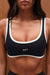 Black sports bra with white trim featuring the brand 'SET' on a brown background