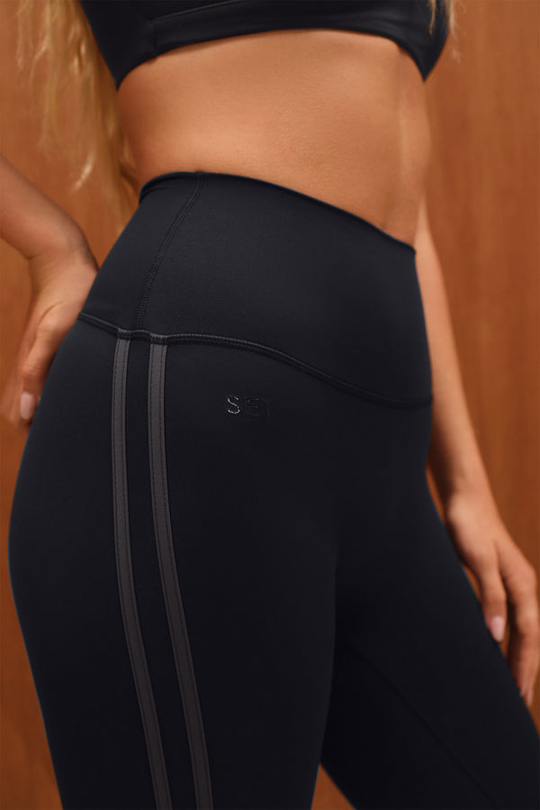 Black leggings with a brand logo on a brown background