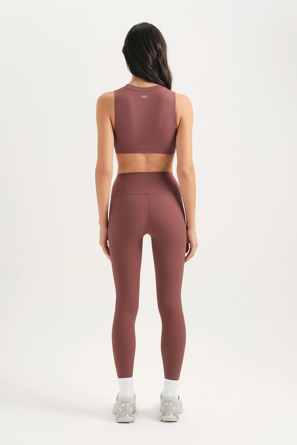 Person wearing a brown athletic outfit on a white background