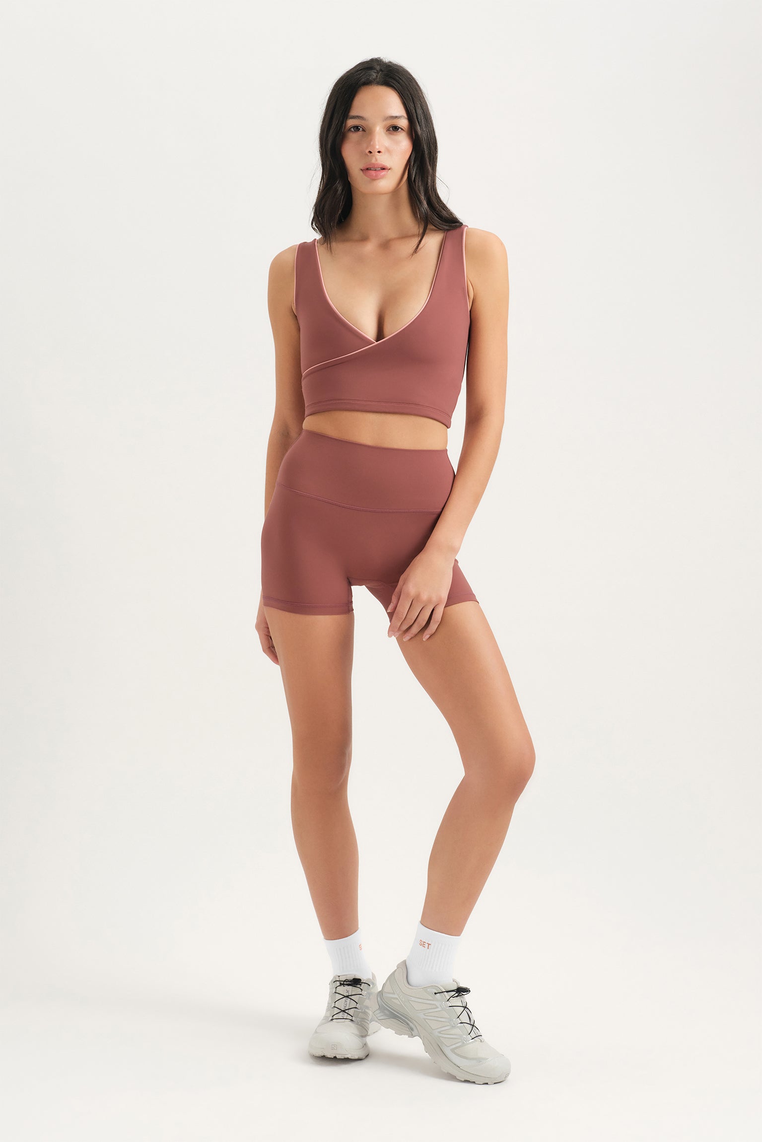 Woman wearing a brown athletic outfit on a white background