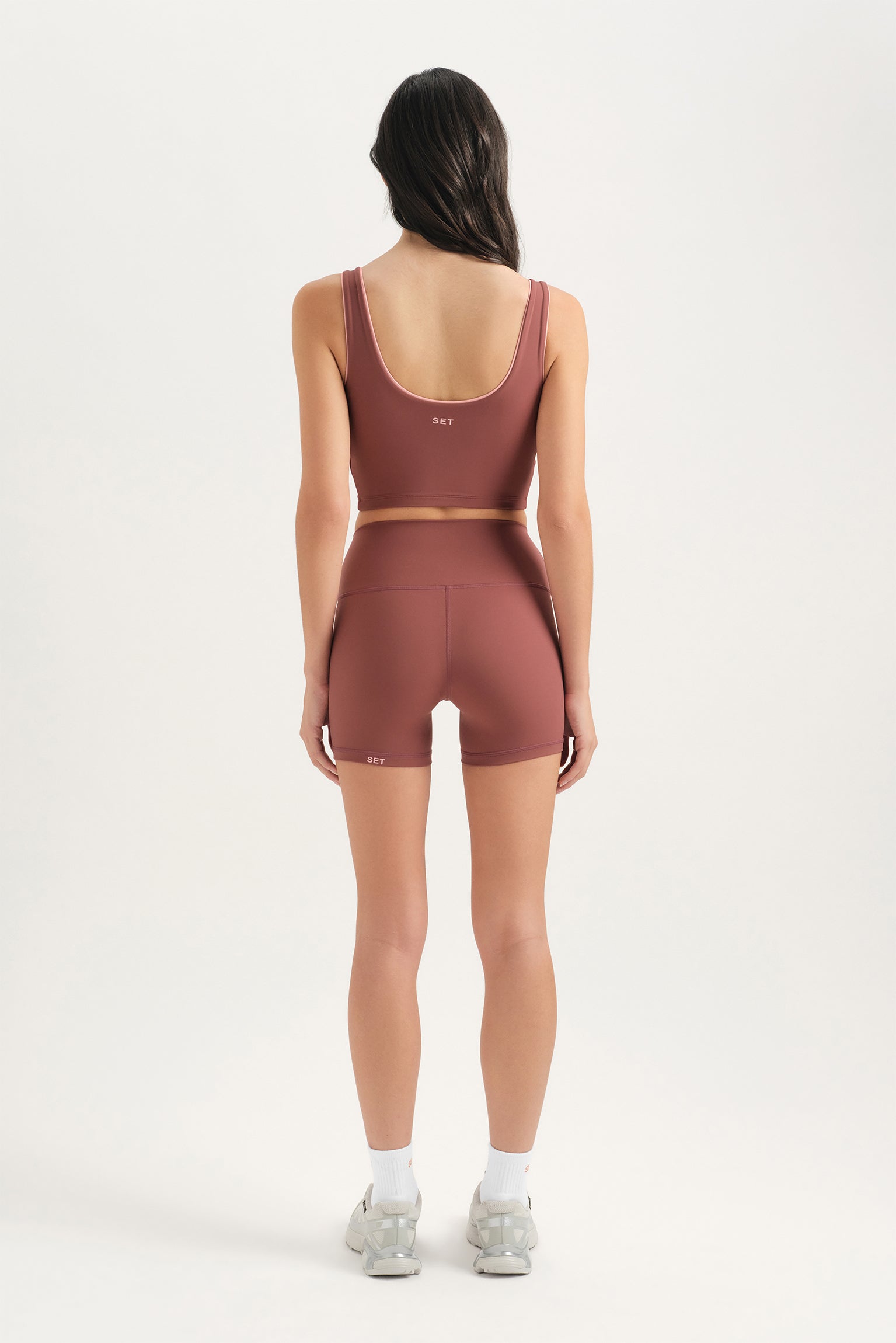 Person wearing a matching sports bra and shorts set on a white background