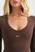 Brown long-sleeve top with 'SET' logo worn by a model on a white background