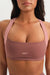 Woman wearing a brown sports bra with 'SET' branding on a white background