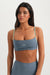 Woman wearing a blue sports bra and leggings with 'SET' branding on a white background <model-info>Sydnee wears a size XS and is 5'8", 22” waist, 32BB bust.</model-info>
