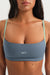 Woman wearing a blue sports bra with 'SET' branding on a white background