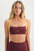 Woman wearing a maroon sports bra with yellow straps on a white background <model-info>Grace wears a size XS and is 5'8", 25" waist, 32" bust.</model-info>