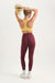 Person wearing a yellow sports bra and maroon leggings on a white background