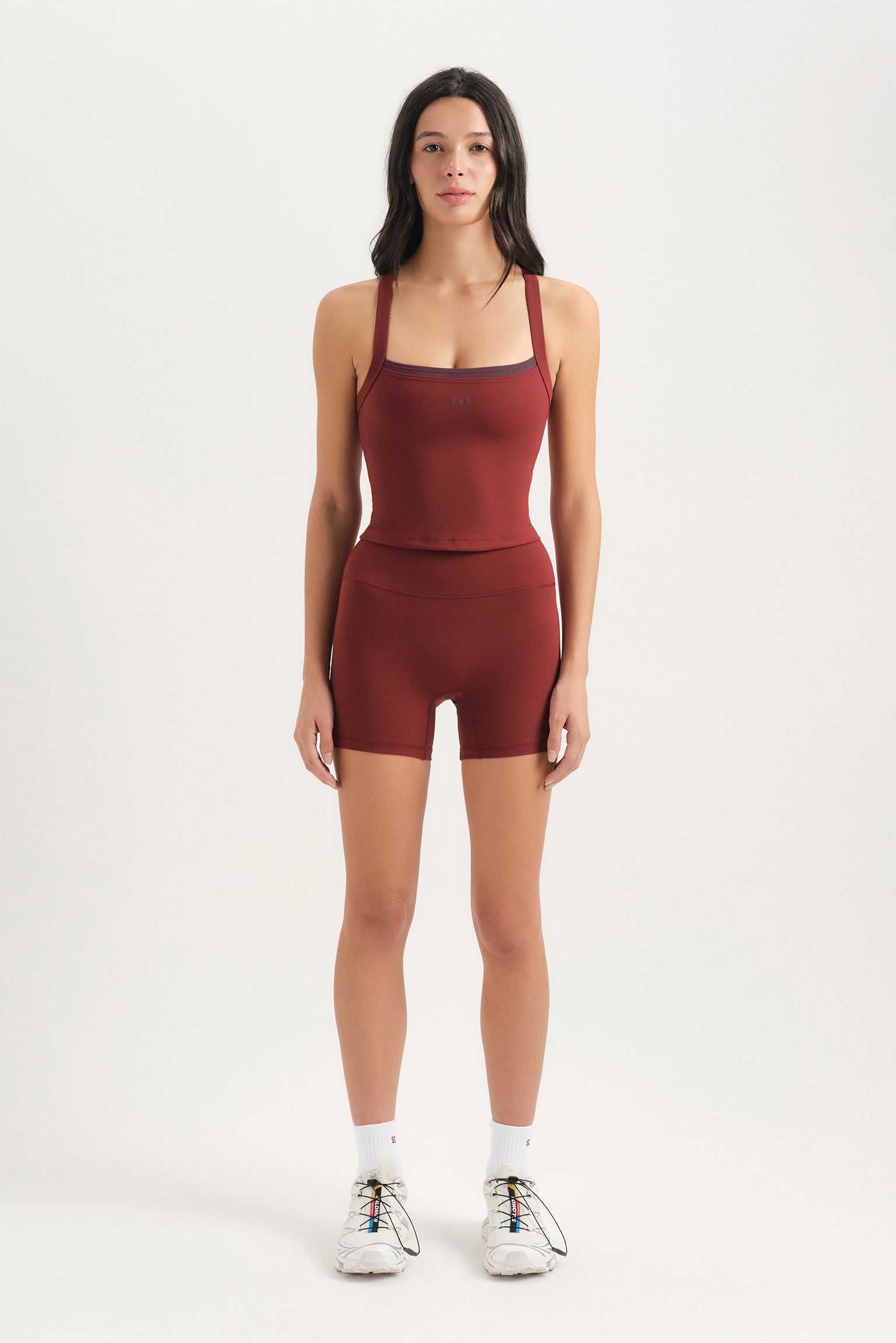 Woman wearing a red athletic outfit on a white background