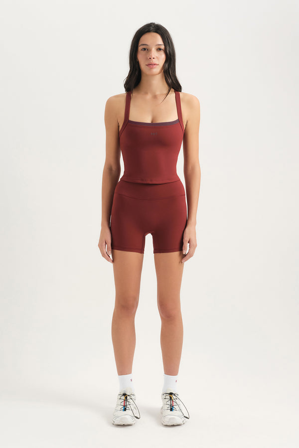 Woman wearing a red athletic outfit on a white background