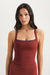 Woman wearing a red tank top against a white background <model-info>Casey wears a size S and is 5’9”, 24” waist, 32B bust.</model-info>