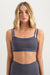 Woman wearing a gray sports bra and leggings on a white background <model-info>Grace wears a size XS and is 5'8", 25" waist, 32" bust.</model-info>
