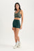 Woman wearing a green sports bra and shorts set on a white background