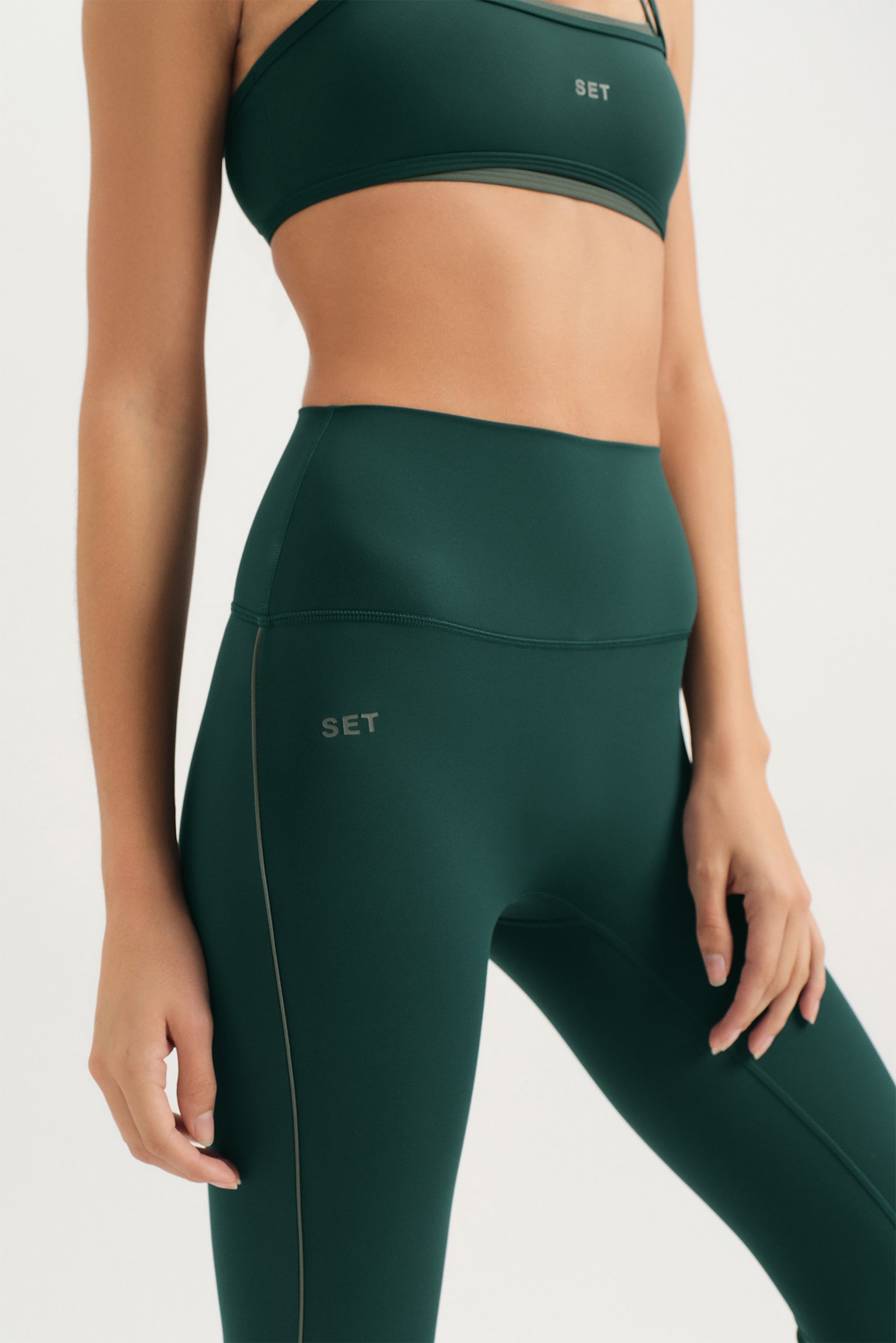 Person wearing green sports bra and leggings with 'SET' branding on a white background