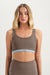 Woman wearing a brown sports bra and leggings on a white background <model-info>Grace wears a size XS and is 5'8", 25" waist, 32" bust.</model-info>