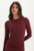 Woman wearing a burgundy long-sleeve top on a white background <model-info>Jelene wears a size XS and is 5’7”, 23” waist, 32AB bust.</model-info>
