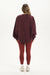 Person wearing a maroon sweatshirt and leggings on a white background