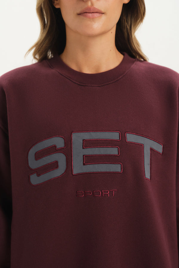 Maroon sweatshirt with 'SET Sport' logo on a plain background