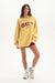 Woman wearing a yellow 'SET' sweatshirt on a white background