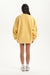 Person wearing a yellow oversized sweater on a white background