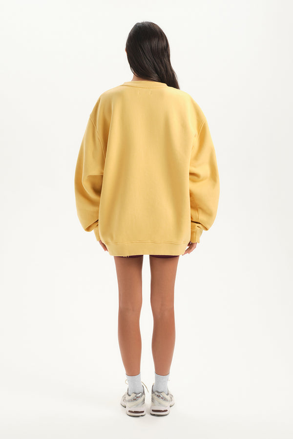 Person wearing a yellow oversized sweater on a white background