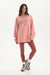 Woman wearing a pink 'SET' oversized sweatshirt and leggings on a white background