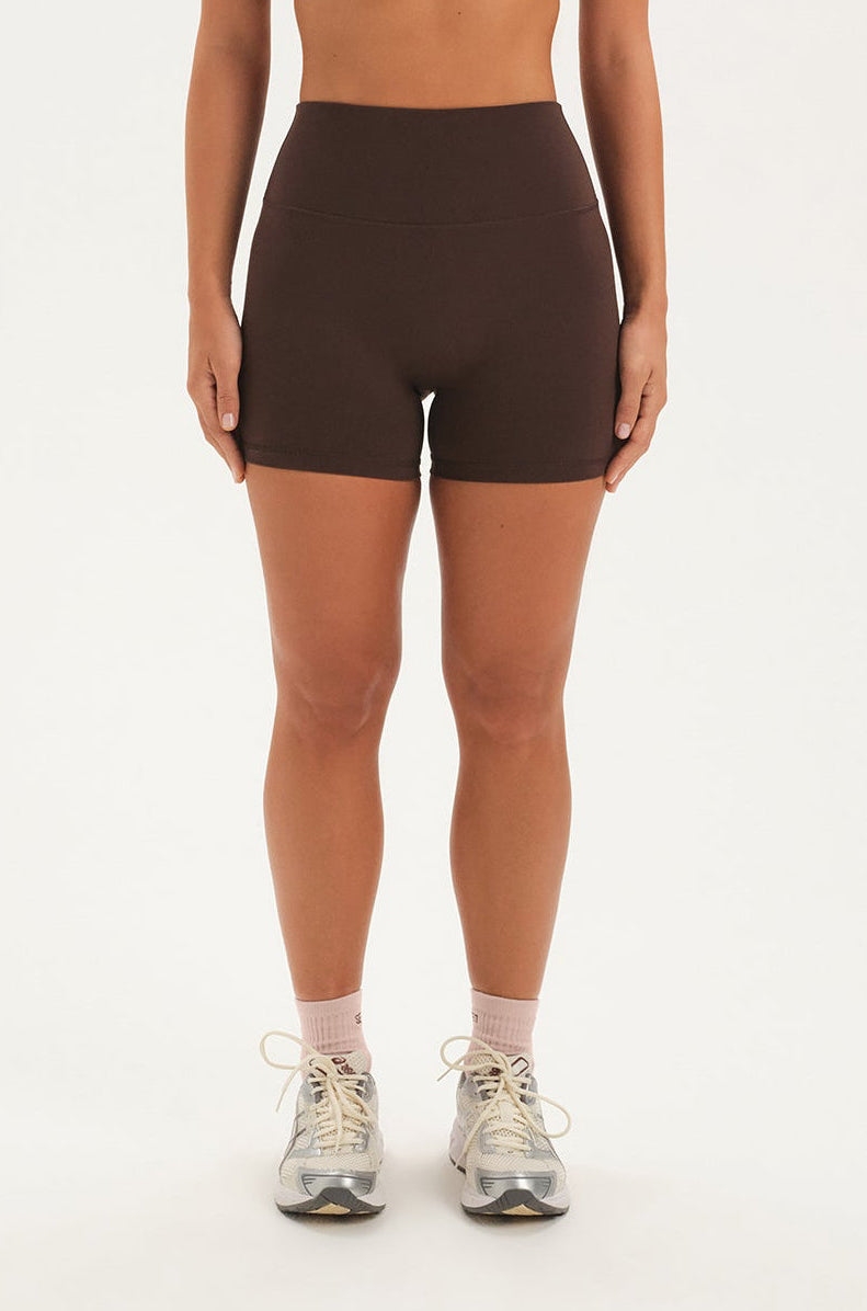 Person wearing brown shorts on a white background <model-info>Bre wears a size M and is 5’7”, 25½" waist, 33” bust.</model-info>