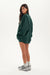 Person wearing a green oversized sweatshirt on a white background