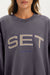 Gray sweatshirt with 'SET Sport' text worn by a person
