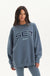 Woman wearing a blue 'SET Sport' sweatshirt on a white background <model-info>Jelene wears a size L and is 5’7”, 23” waist, 32AB bust.</model-info>