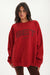 Woman wearing a red sweatshirt with 'SET' logo on a white background <model-info>Jelene wears a size L and is 5’7”, 23” waist, 32AB bust.</model-info>