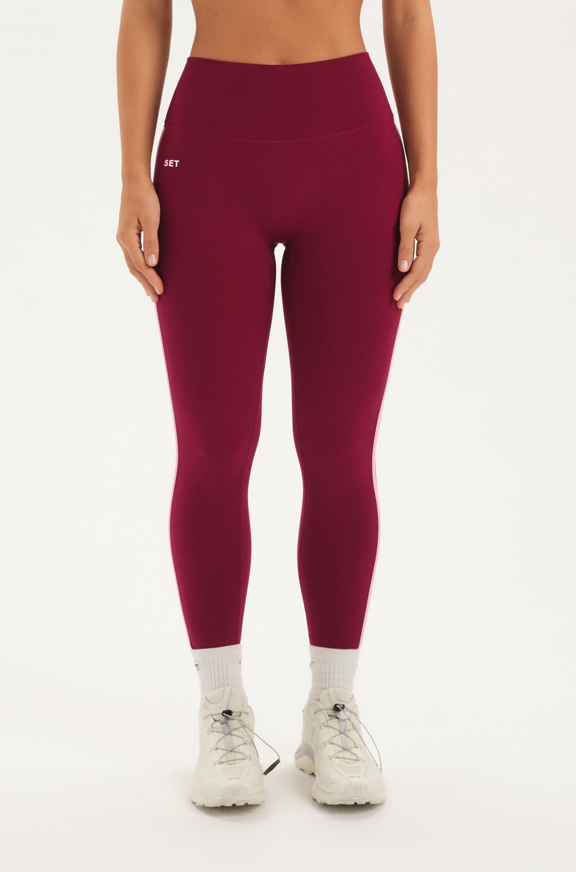 Woman wearing a maroon leggings on a white background <model-info>Bre wears a size M and is 5’7”, 25½" waist, 33” bust.</model-info>