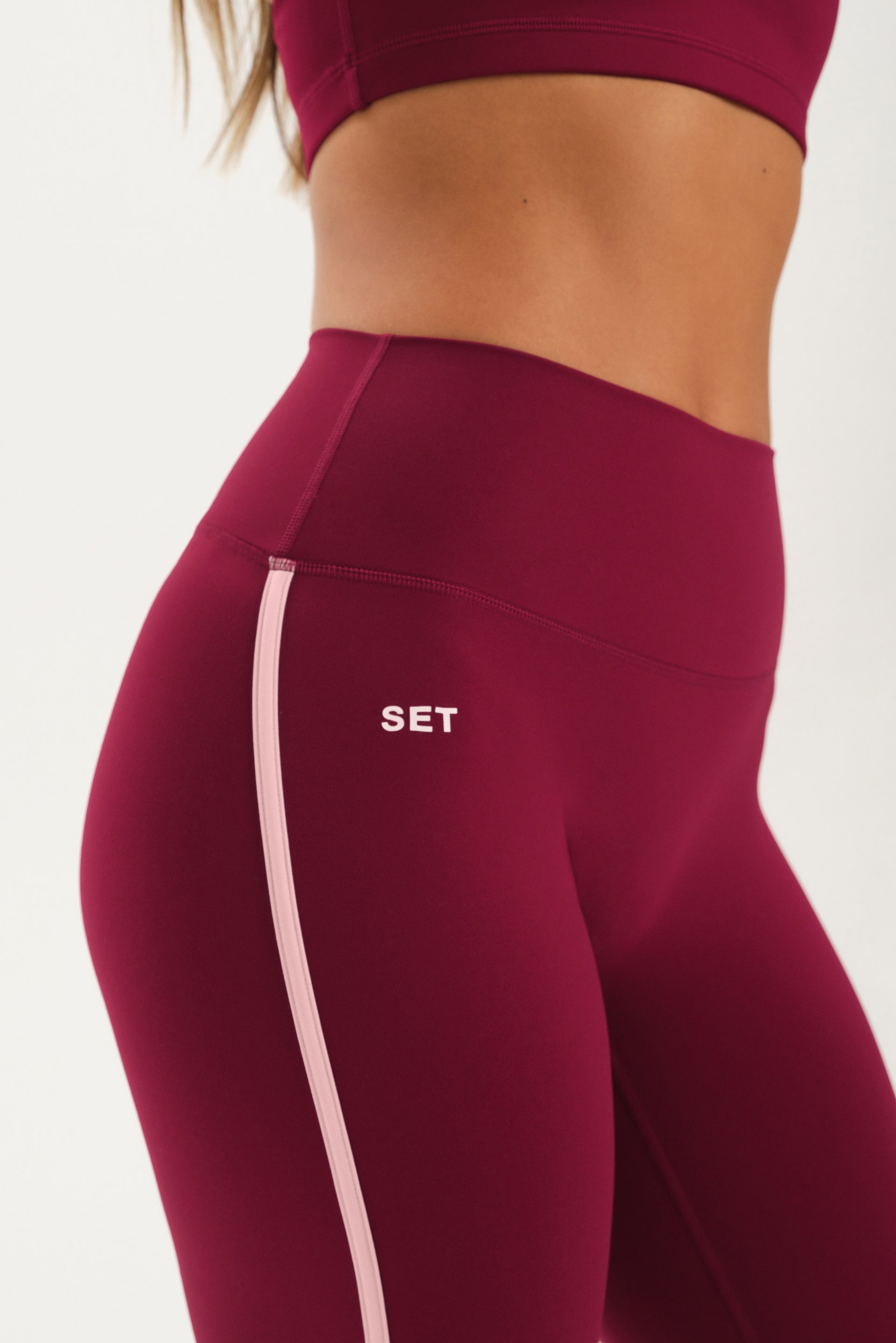 Maroon leggings with a pink stripe and 'SET' logo on a white background