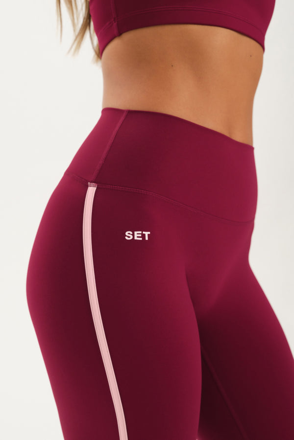 Maroon leggings with a pink stripe and 'SET' logo on a white background