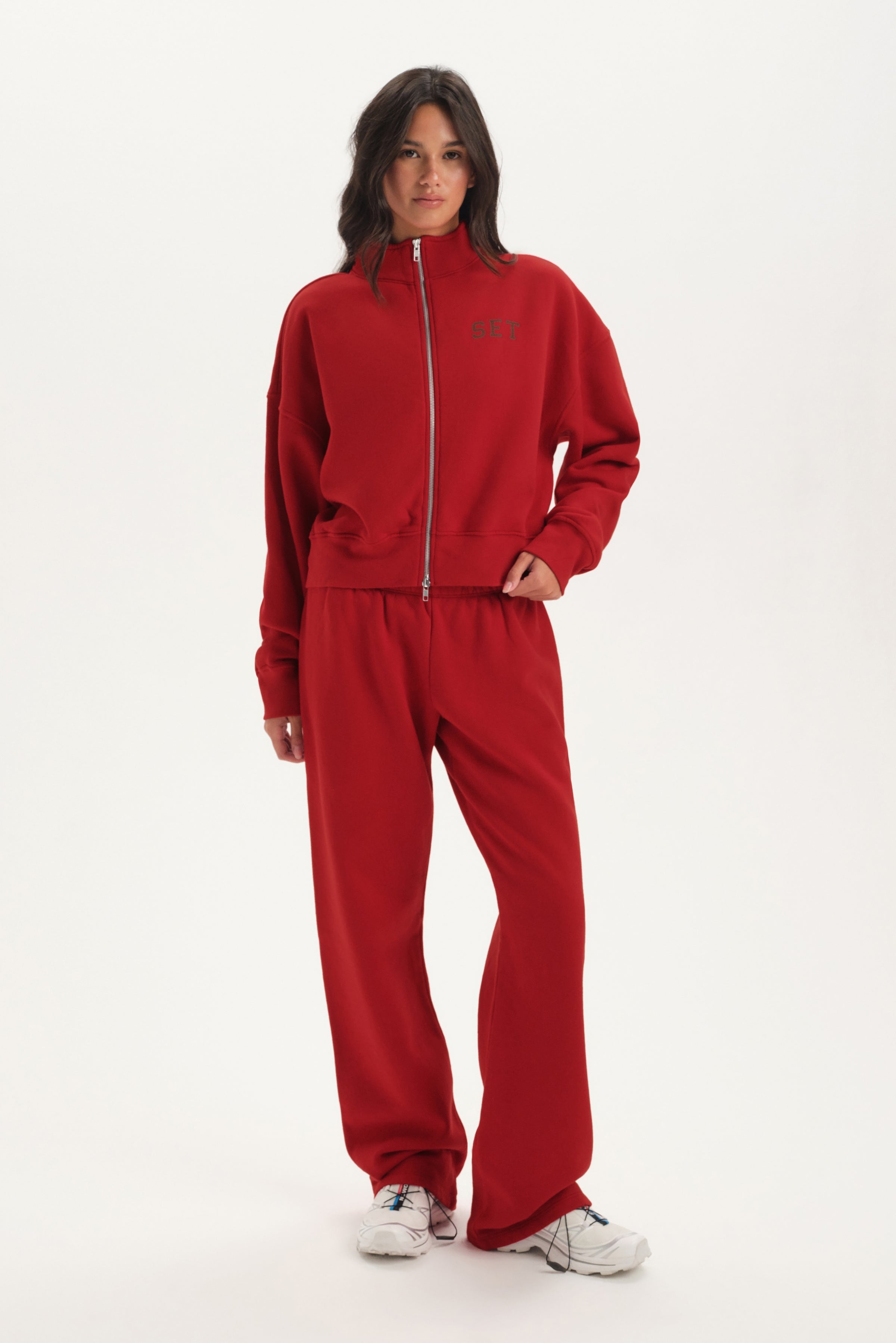 Person wearing a red tracksuit on a white background 