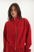 Person wearing a red zip up with 'SET' branding on a white background <model-info>Jelene wears a size S and is 5’7”, 23” waist, 32AB bust.</model-info>