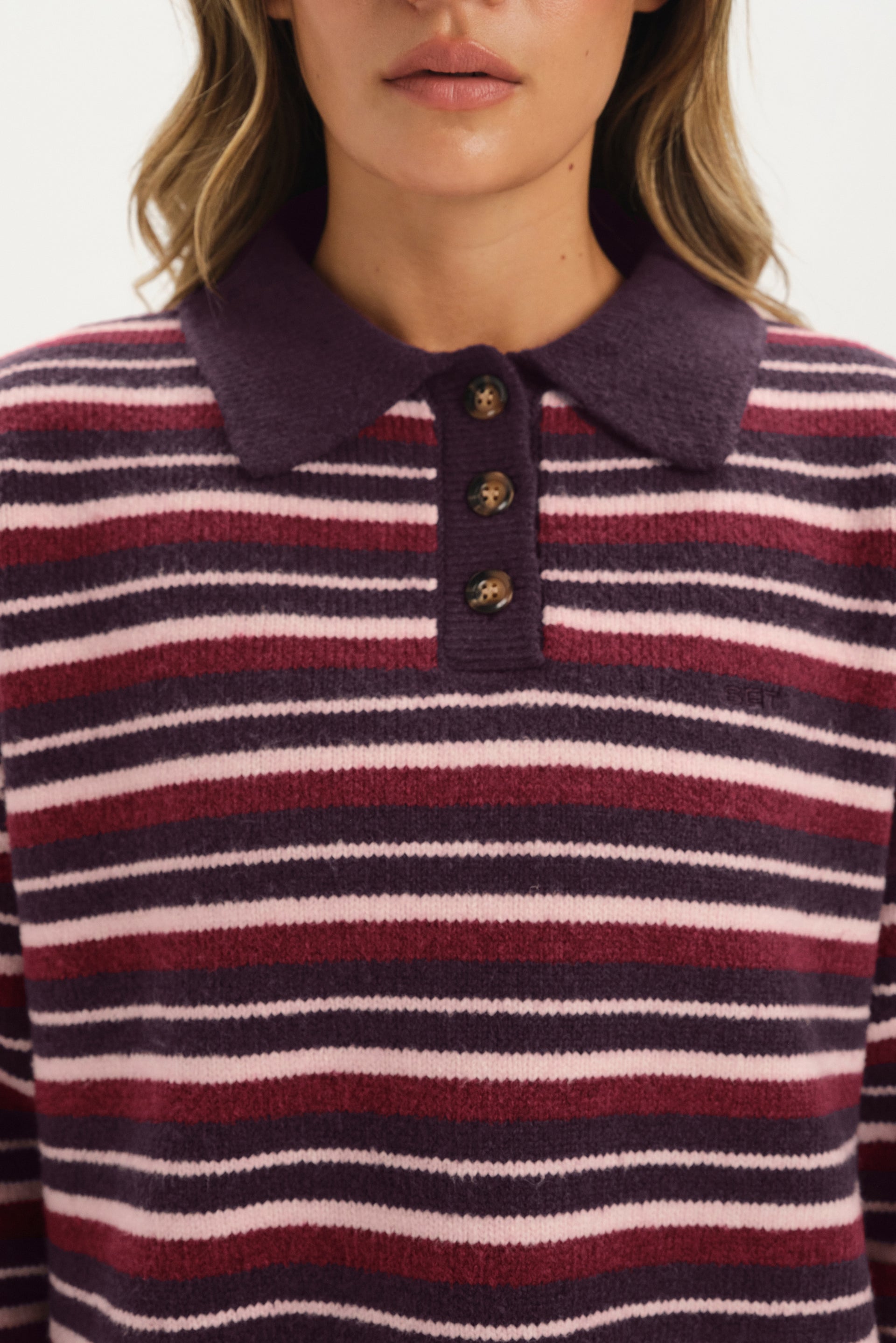 Close-up of a person wearing a striped sweater with a collar.