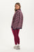 Woman wearing a striped sweater and red leggings on a white background