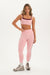 Woman wearing a pink athletic outfit on a white background