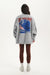 Person wearing a gray sweatshirt with a graphic design on the back, standing against a white background