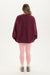 Person wearing a maroon oversized sweatshirt and pink leggings on a white background