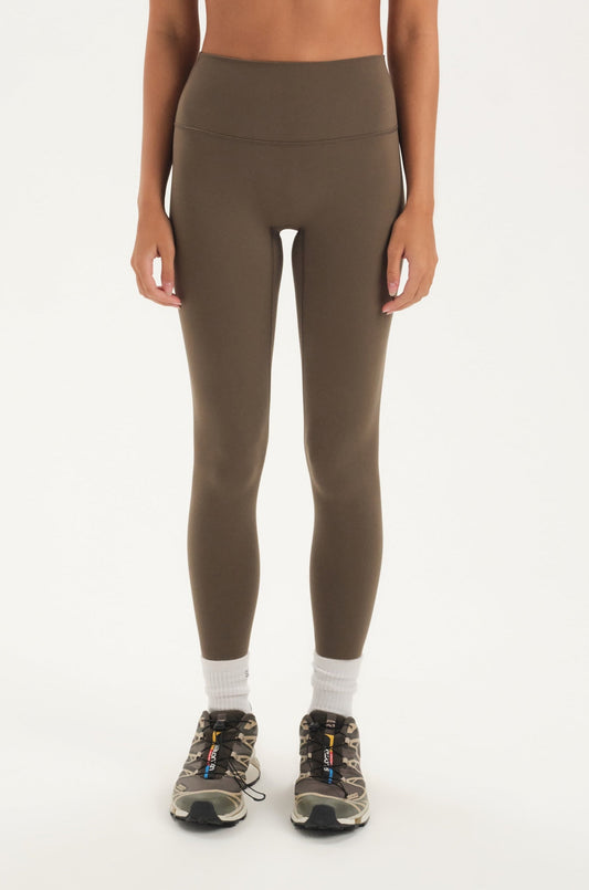 Woman wearing a green leggings on a white background <model-info>Jelene wears a size XS and is 5’7”, 23” waist, 32AB bust.</model-info>