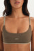 Woman wearing a green sports bra with 'SET' branding on a neutral background