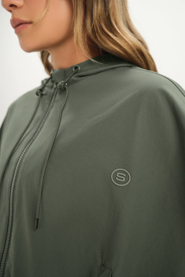 Green jacket with a brand logo on a neutral background