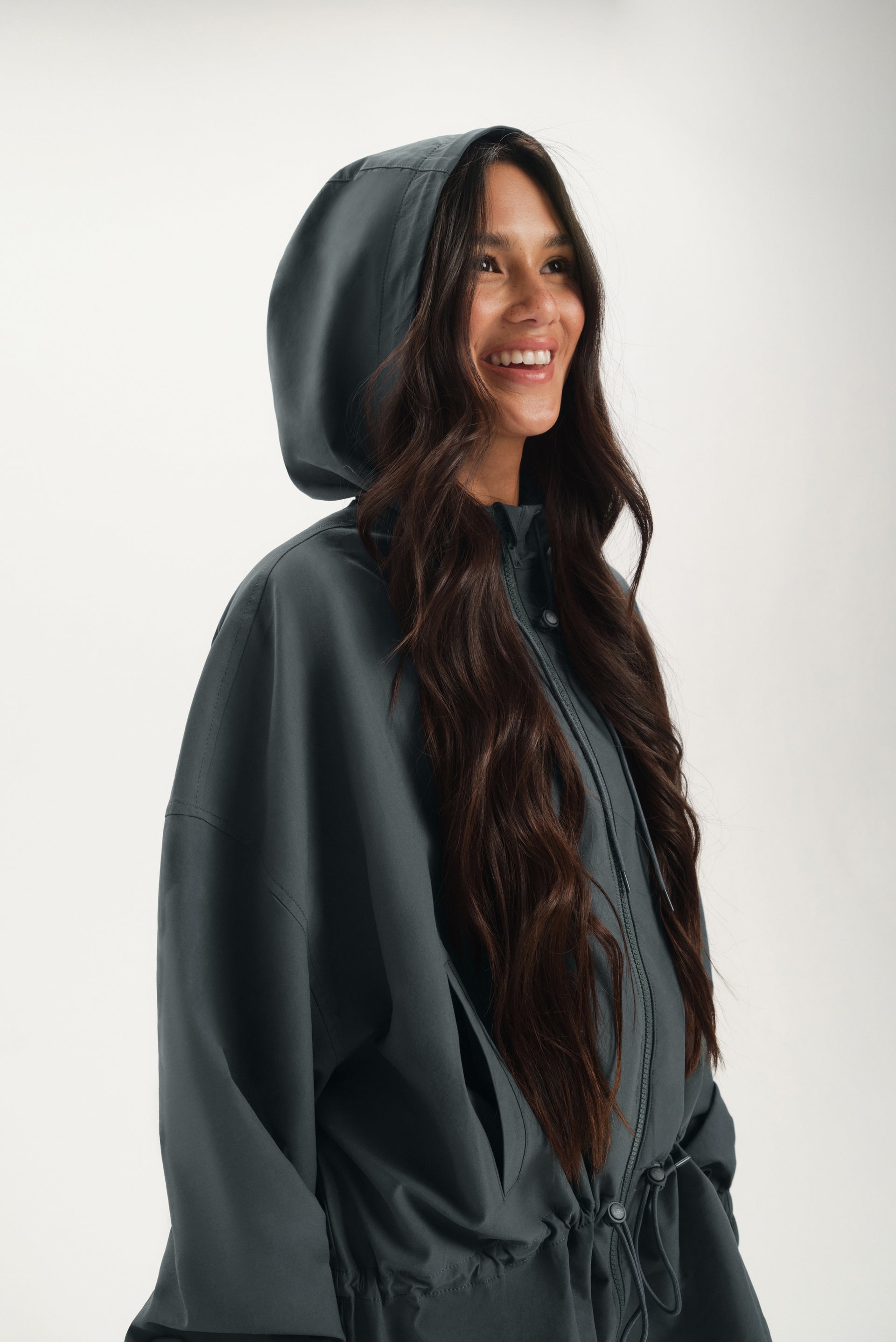 Woman wearing a dark gray hooded jacket on a white background